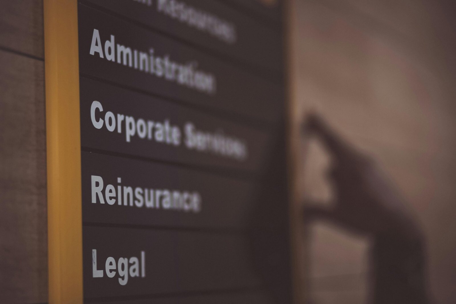 Close-up of an office directory sign showing administration and legal departments.